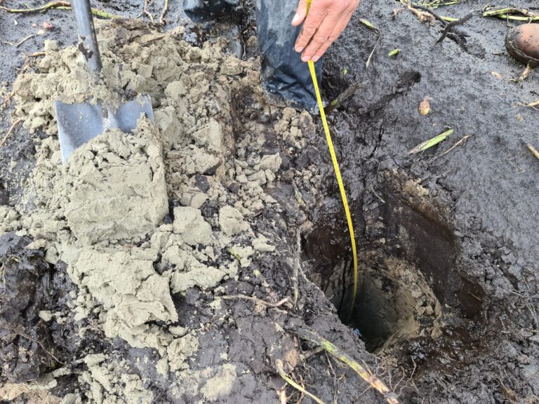 Met schep graven in de bodem voor bodemonderzoek