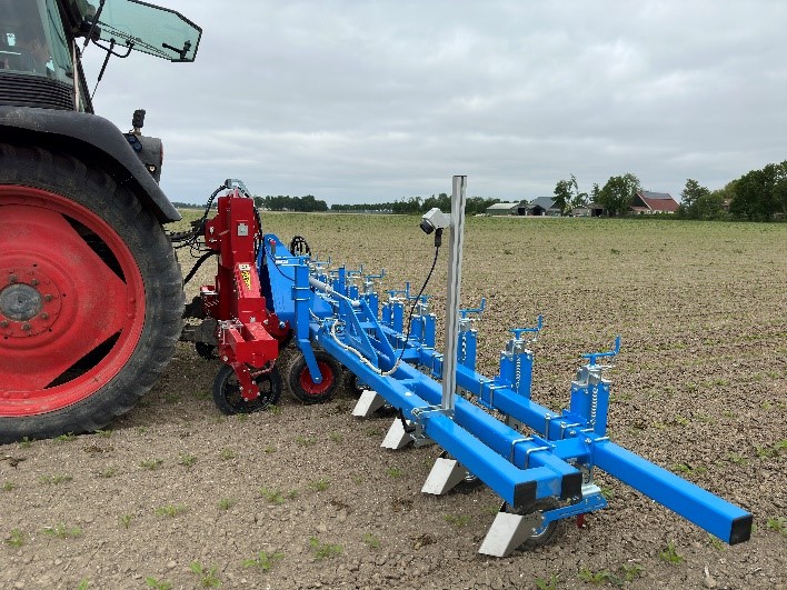 cameragestuurde schoffel achter trekker op perceel voor onkruidbestrijding